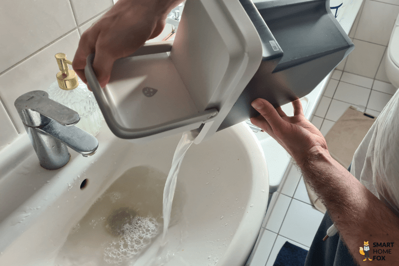 Грязная вода выливается из резервуара Roborock S8 Pro в раковину.